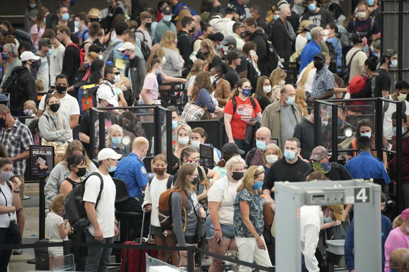 图为普遍戴上口罩的旅客在丹佛国际机场航站大厅排队等候安检.