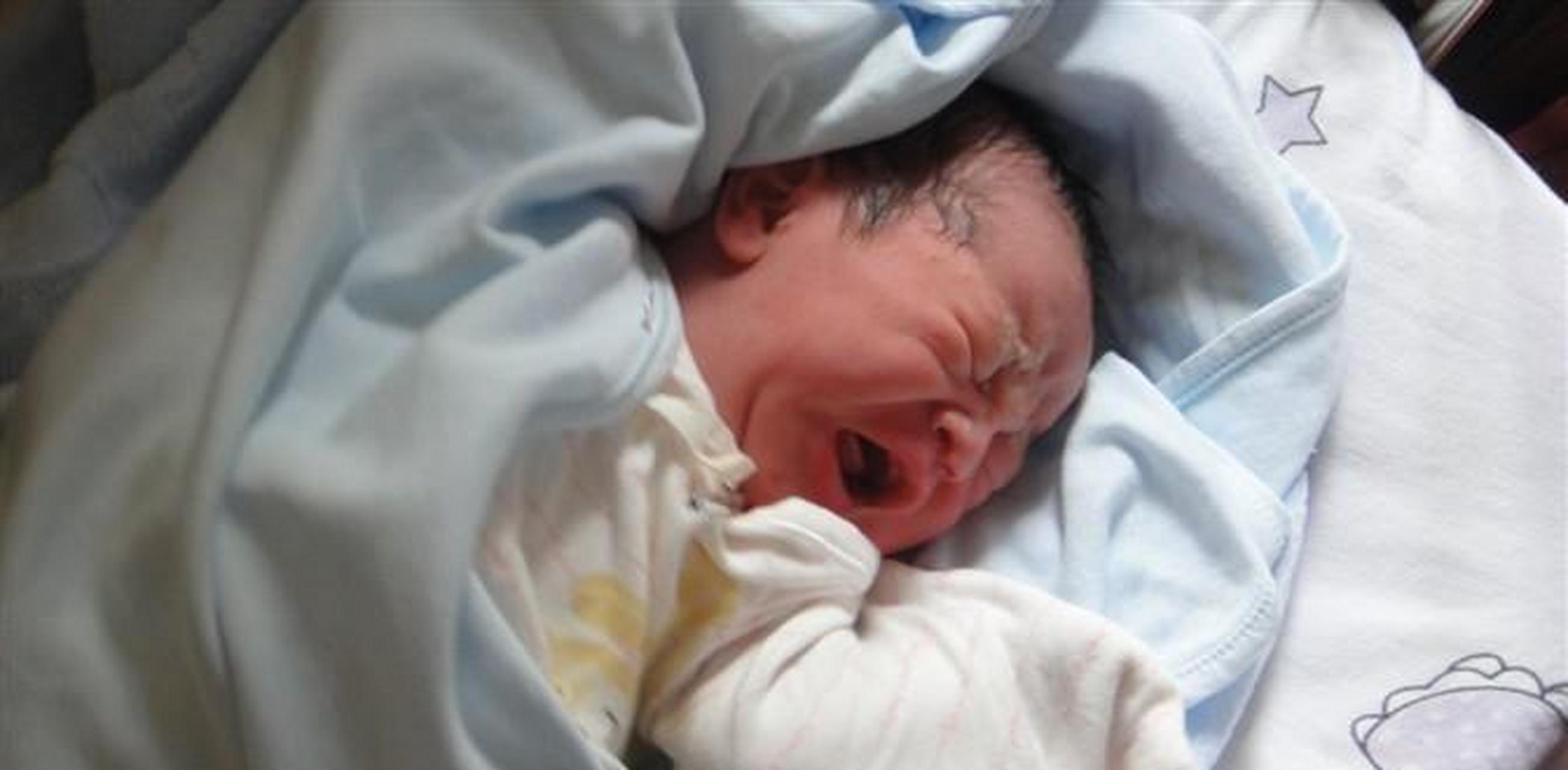 在合肥的一家殡仪馆里,火化员正准备把一名婴儿的尸体放入火化炉.