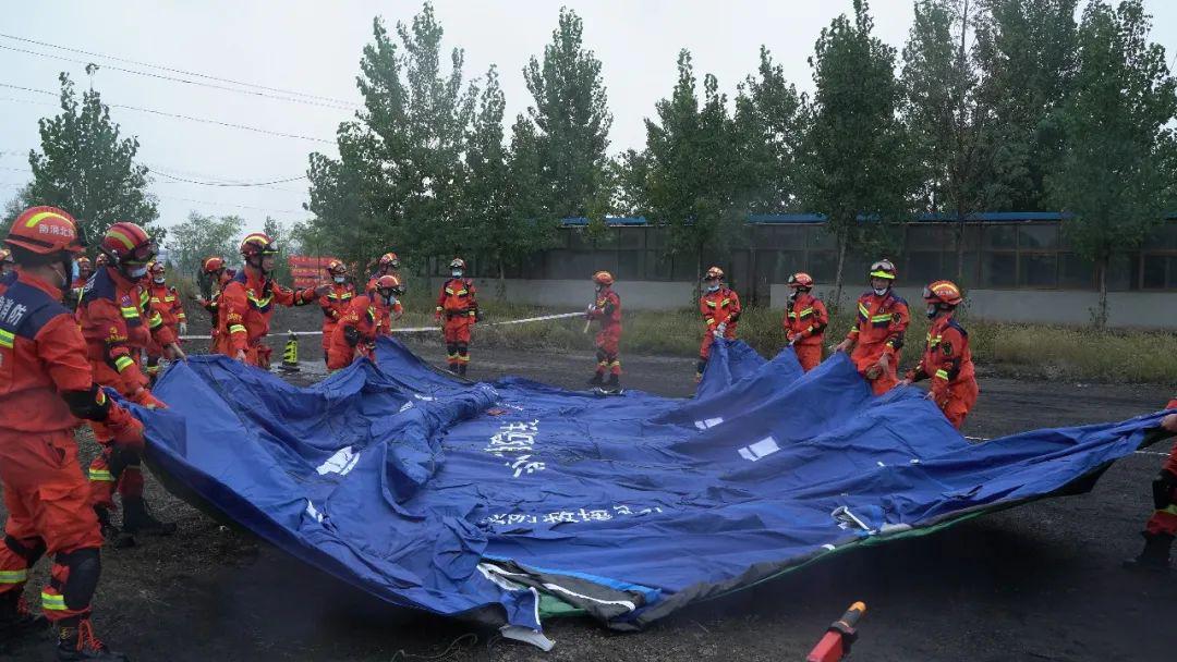 图为消防救援人员正在搭建营地.