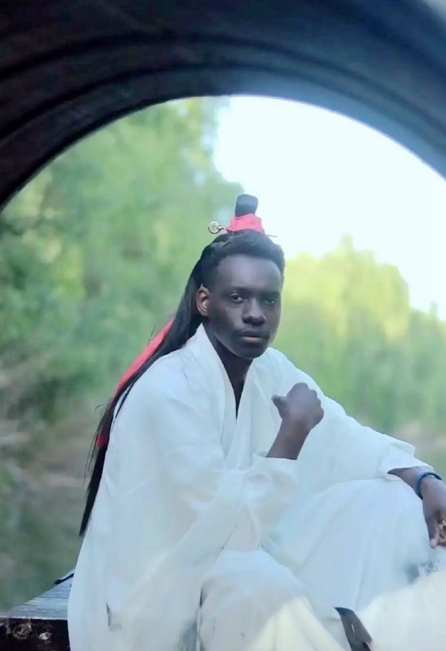 黑人朋友穿着古装.为了看清他的脸,我不自觉地调高了手机屏幕的亮度.