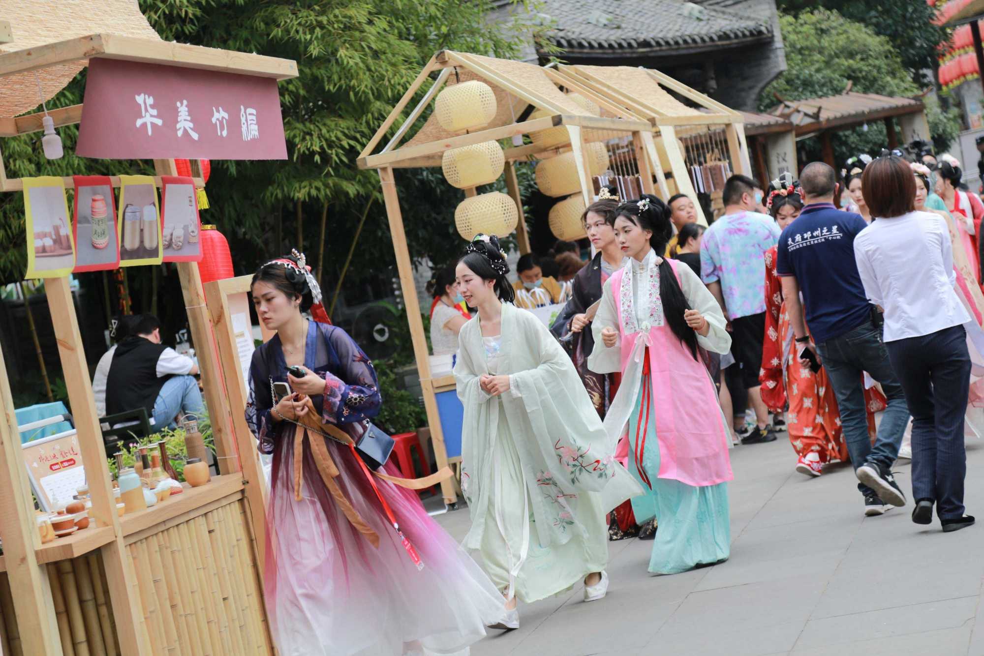 图为活动现场,身着汉服的游客行走古街,形成一道亮丽的风景.