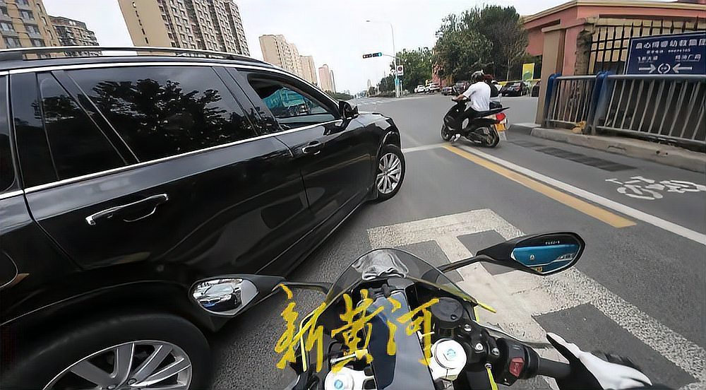 机动车与摩托车交汇处的交通场景，显示车辆等待通行。