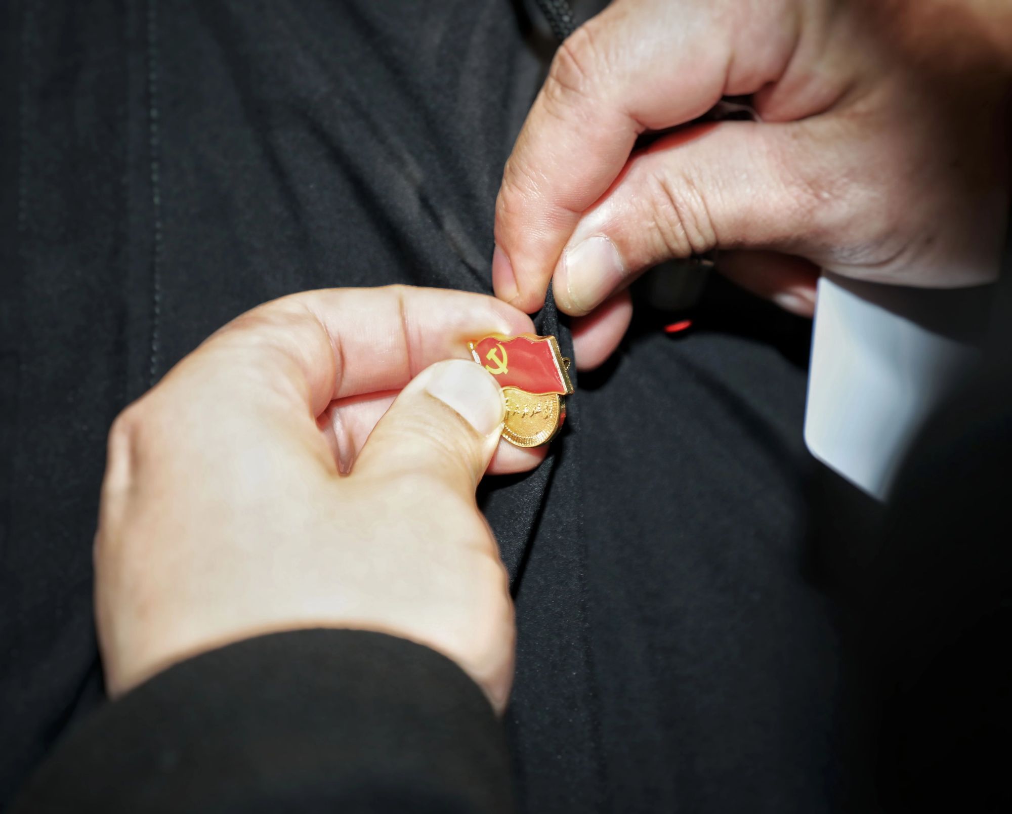 党代表庄重地佩戴好党徽和代表证.