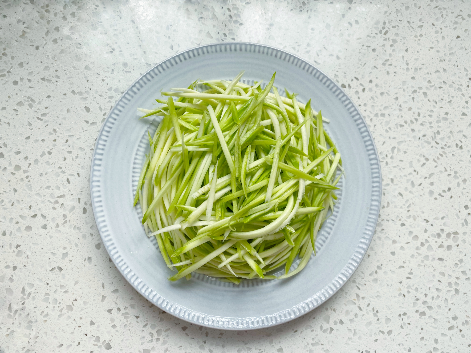 4,把刨好的西葫芦丝,盘起来放在餐盘里,盘成一圈,嫌麻烦的也可以直接