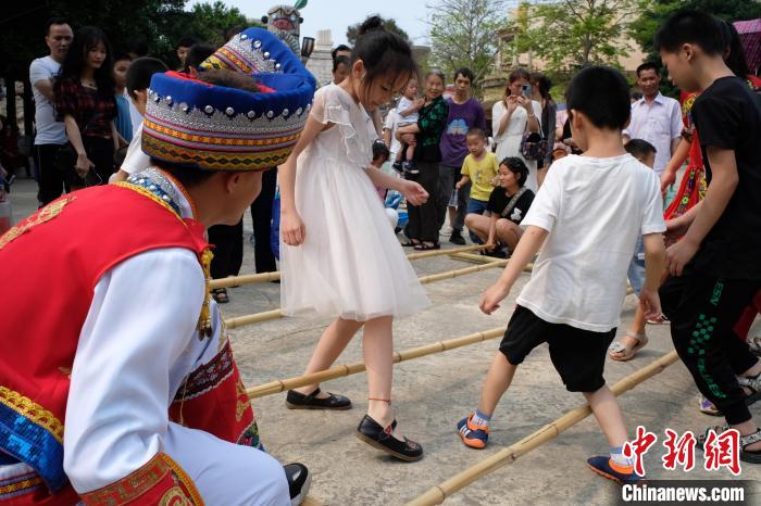 广西壮族三月三:游客共跳竹竿舞