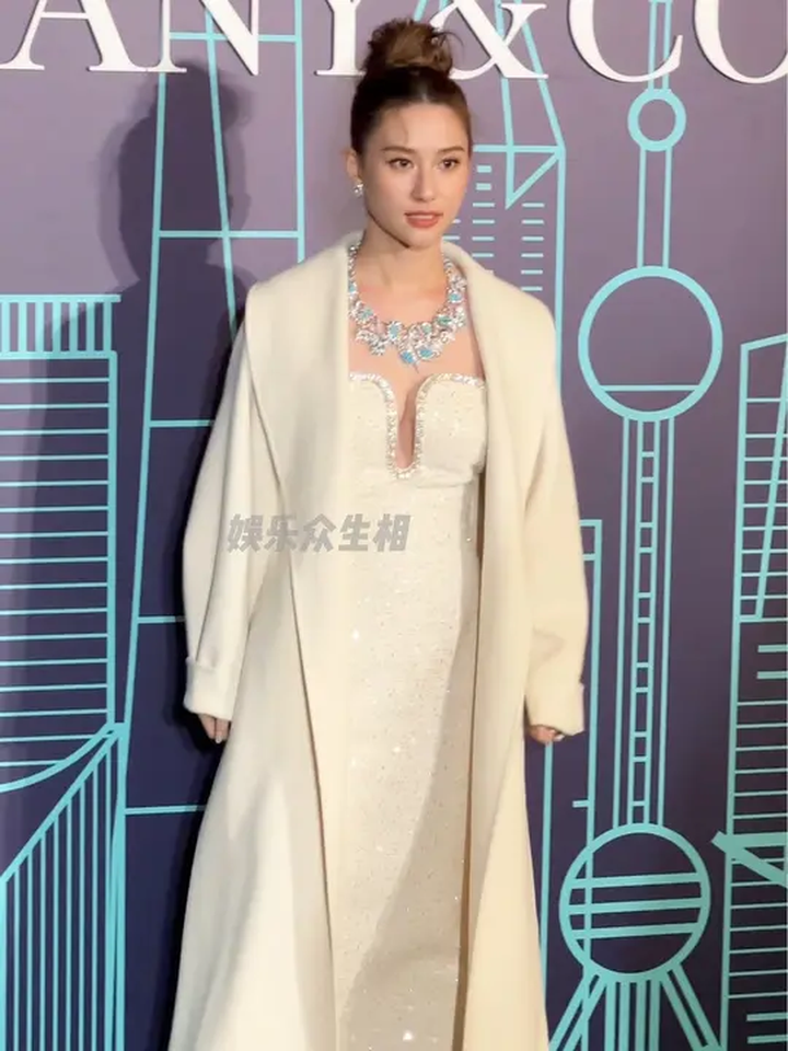 何超莲身着白色大衣的造型,项链闪烁着耀眼的光芒