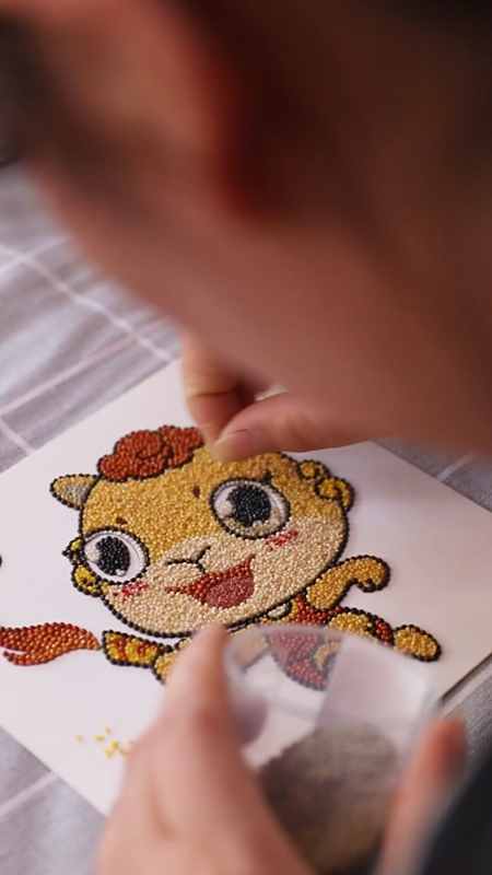 用米脂特有的小米创作"十七运"主题作品,独具创意的米贴画,展示着非遗