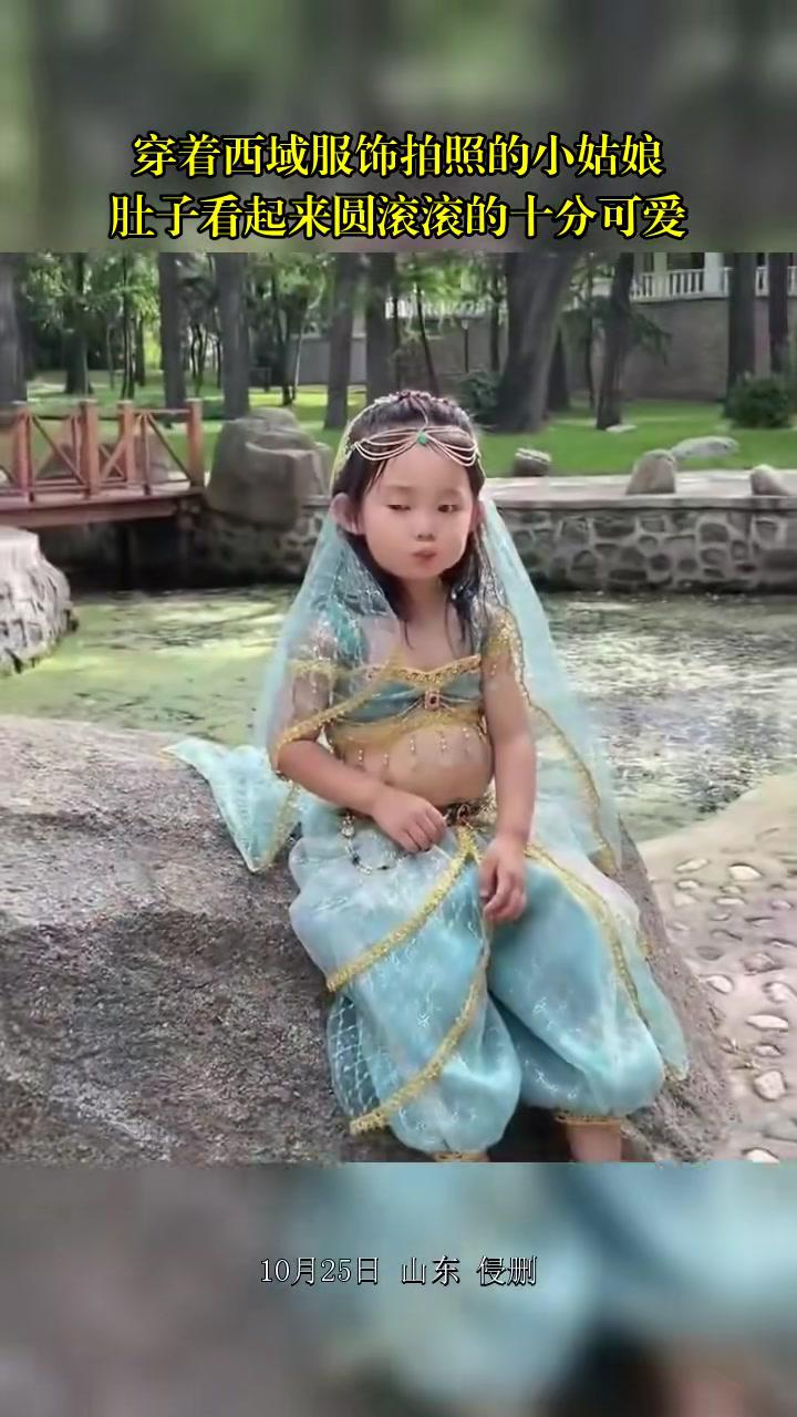 穿着西域服饰拍照的小姑娘,肚子看起来圆滚滚的十分可爱