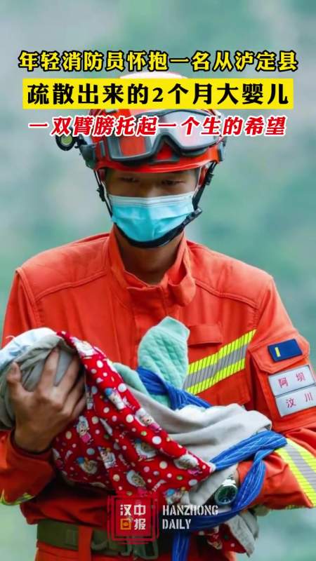 年轻 消防员怀抱一名从 泸定县疏散出来的2个月大婴儿,一双臂膀托起一