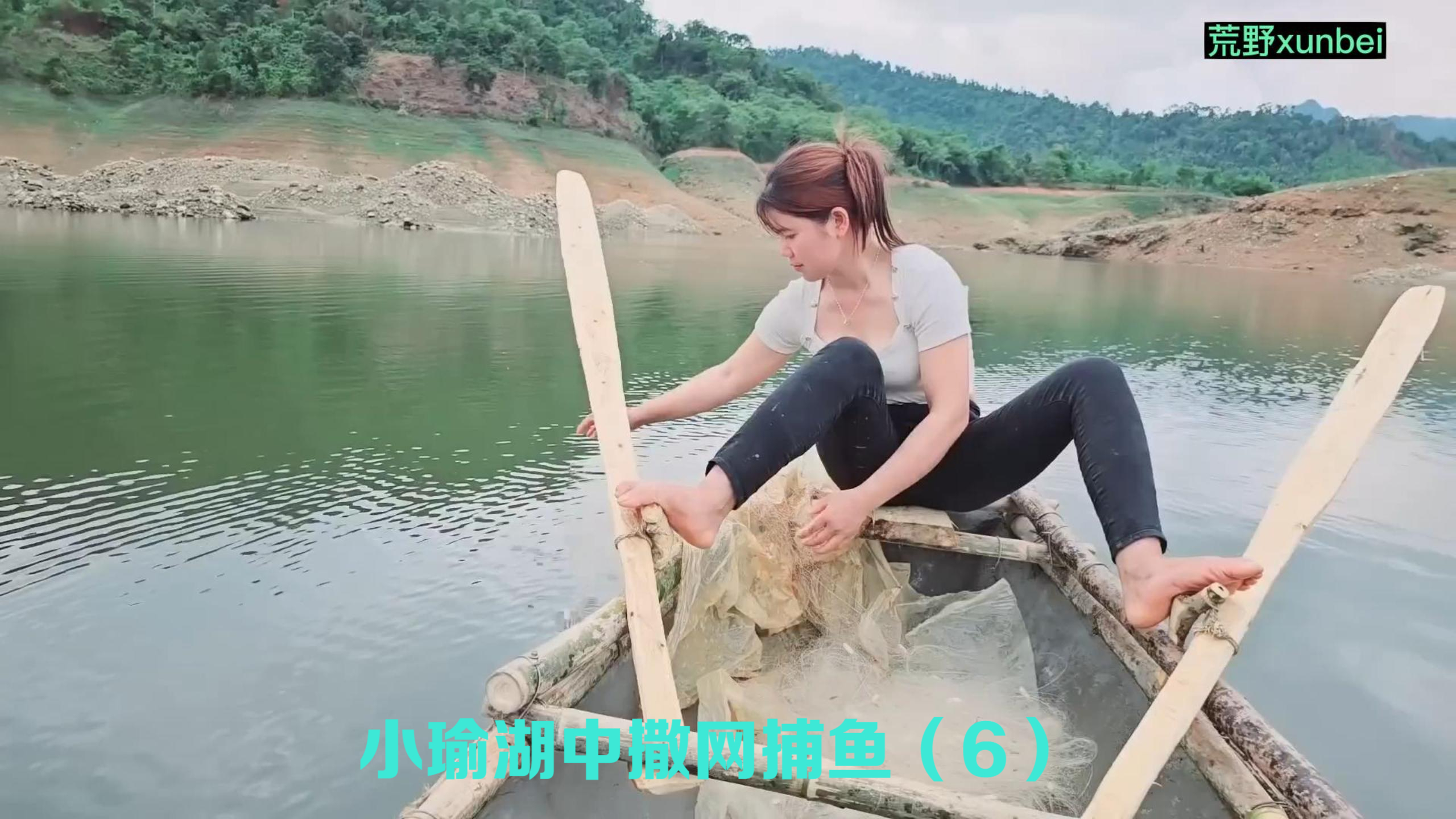 渔家少女脚划双桨驾着小船,湖中撒网捕鱼