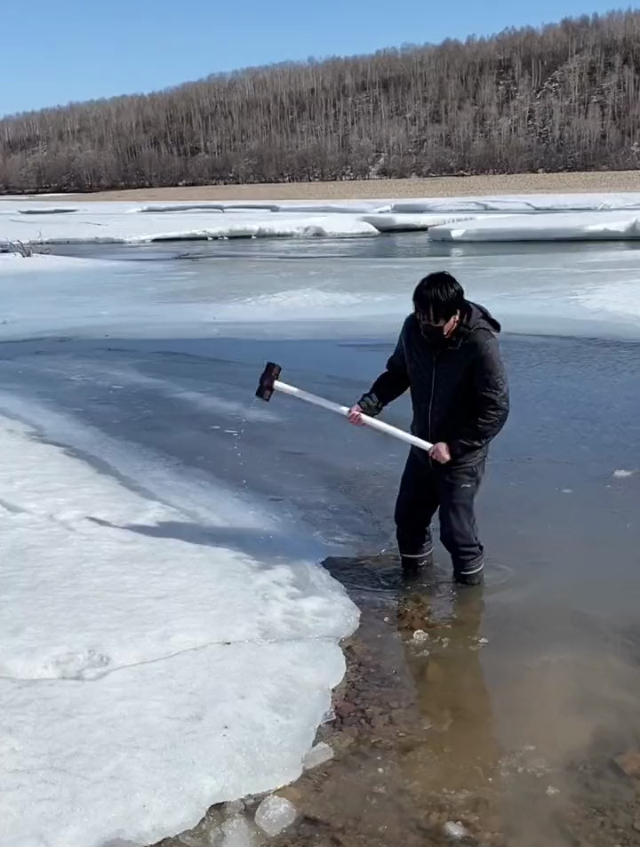 拿大锤子在河边砸冰抓鱼