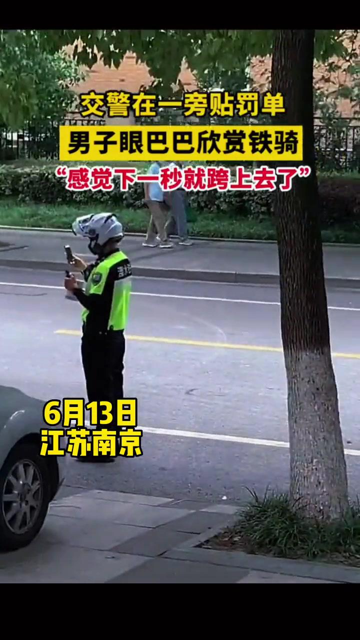 6月13日江蘇南京交警在路邊開罰單時男子仔細欣賞鐵騎好想加入他們好