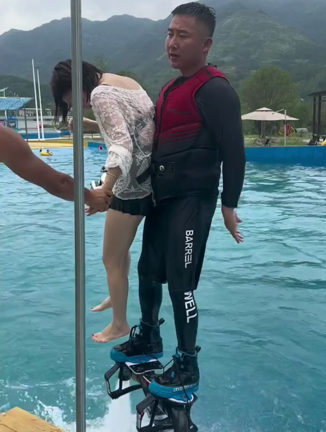 美女来玩水上飞人,教练一只手就抱上了,力气太大了