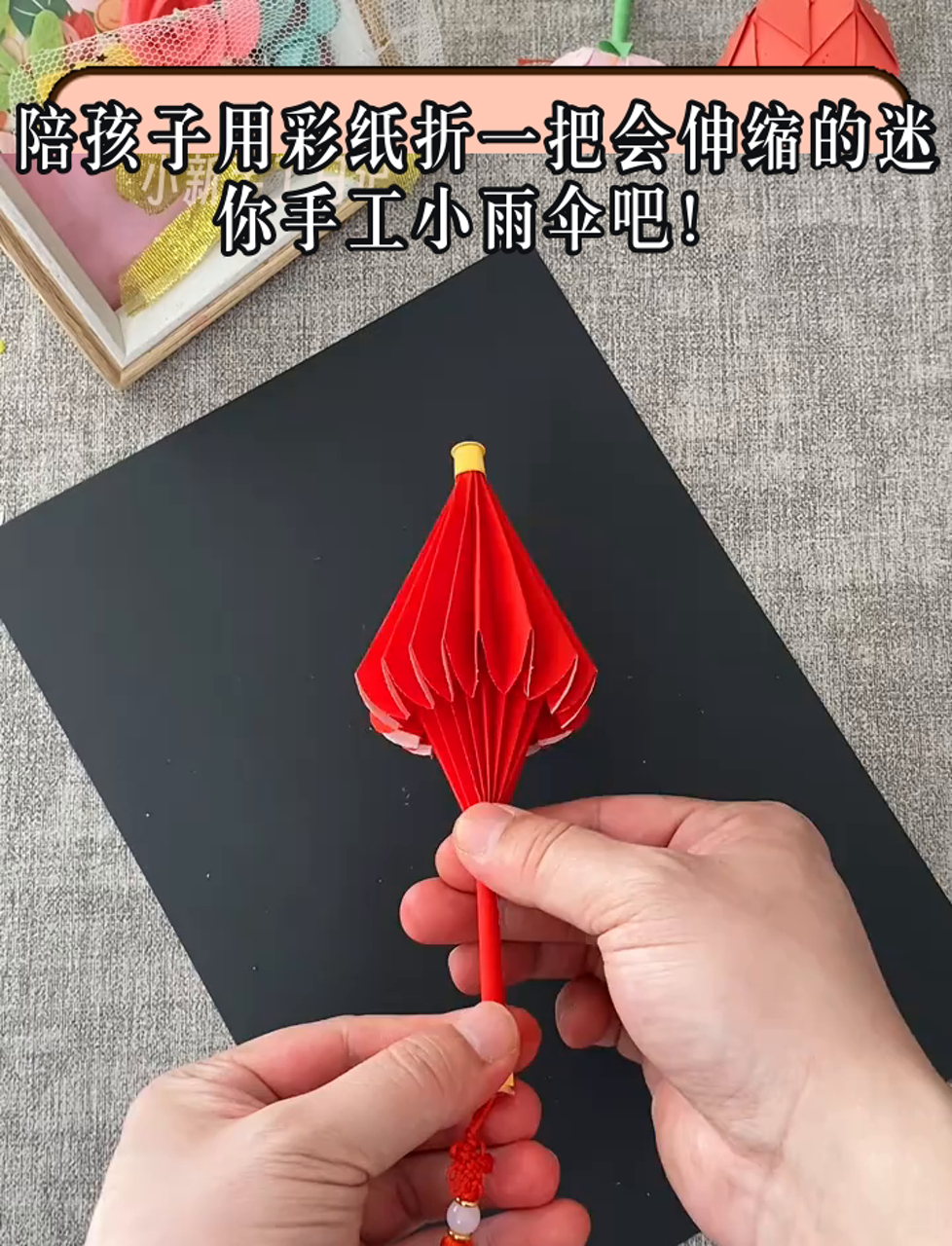 陪孩子用彩纸折一把会伸缩的迷你手工小雨伞吧!
