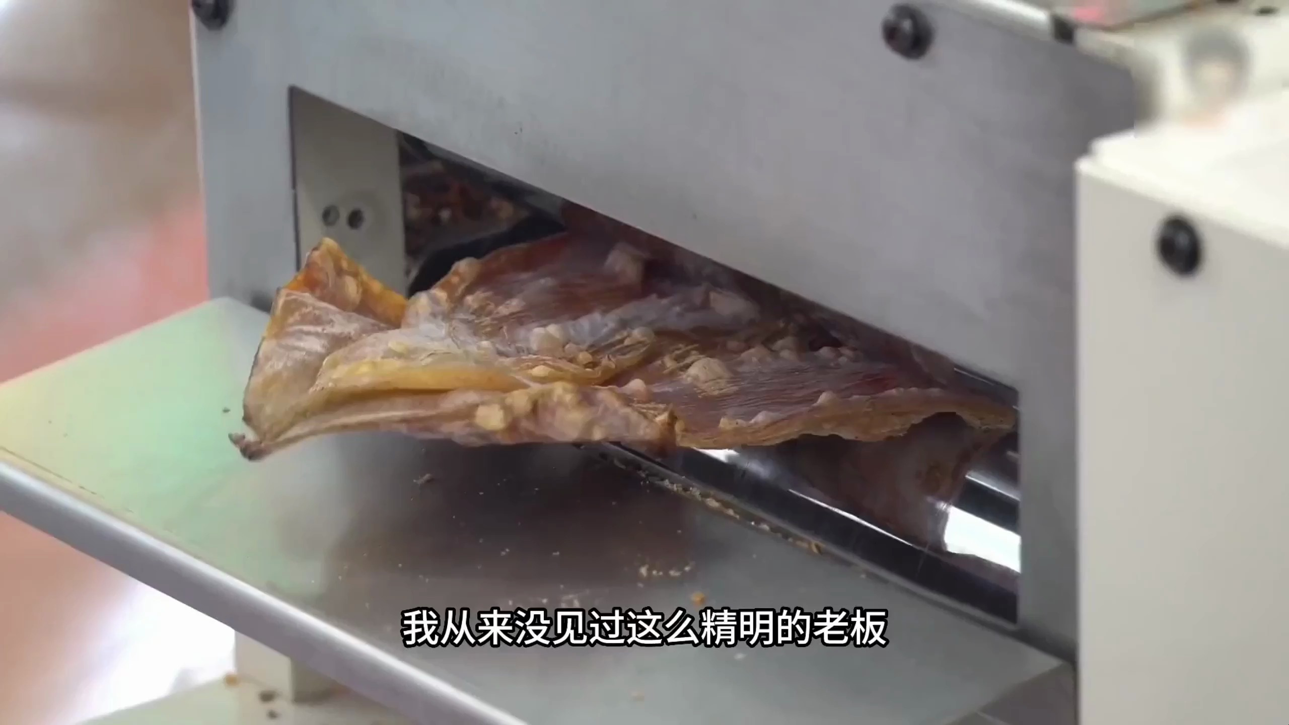 把鱿鱼干先烤热,放入压面机压成薄片,此刻的鱿鱼干也被做精做大