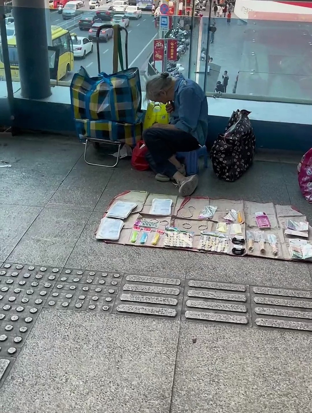 老人独自在天桥摆摊从布包里拿出吃食