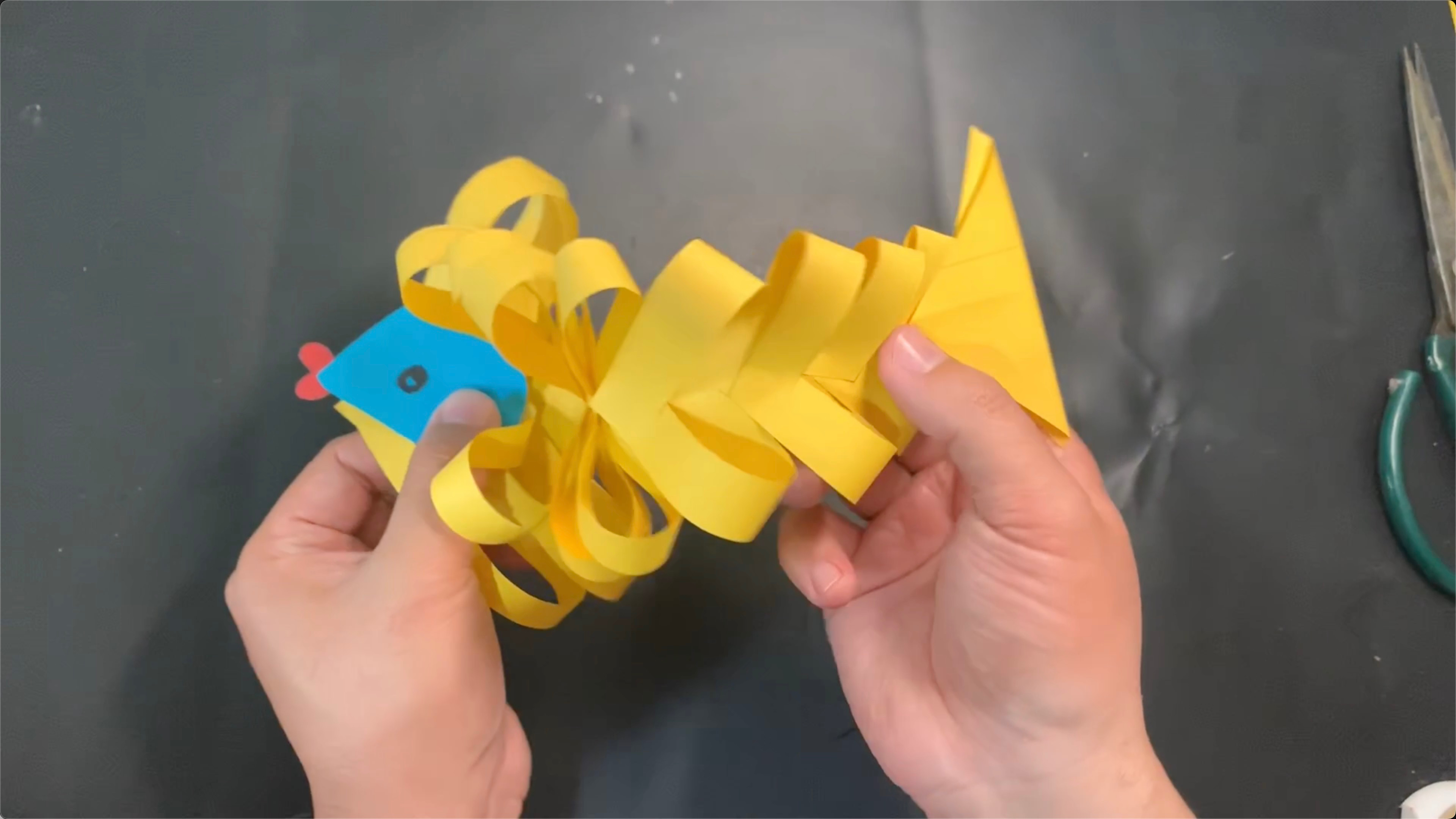 用一张彩纸,做一条可以扭动的立体小鱼,扭来扭去的真好玩