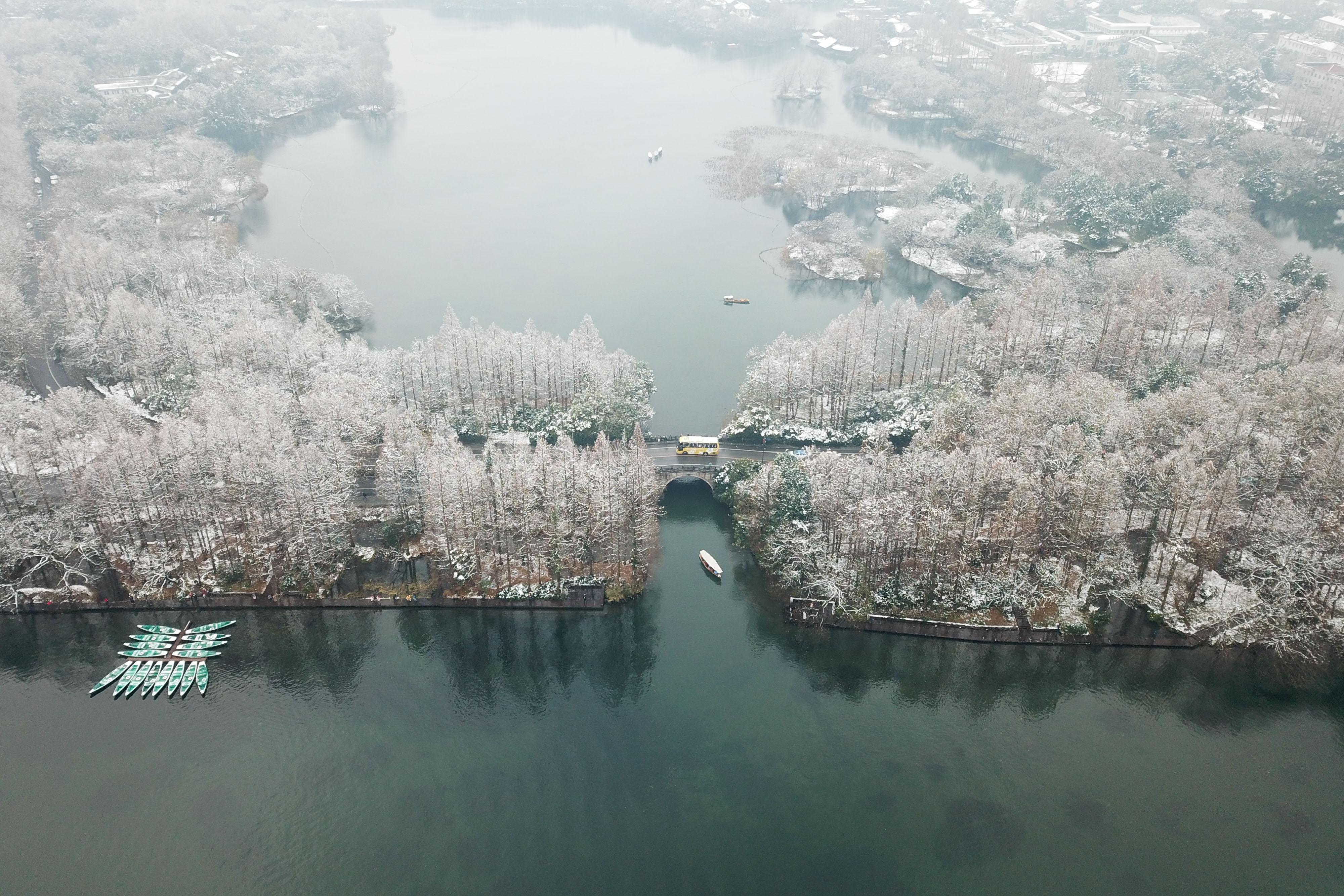 12月31日,一艘手划船在西湖景区杨公堤的桥下穿行(无人机拍摄).