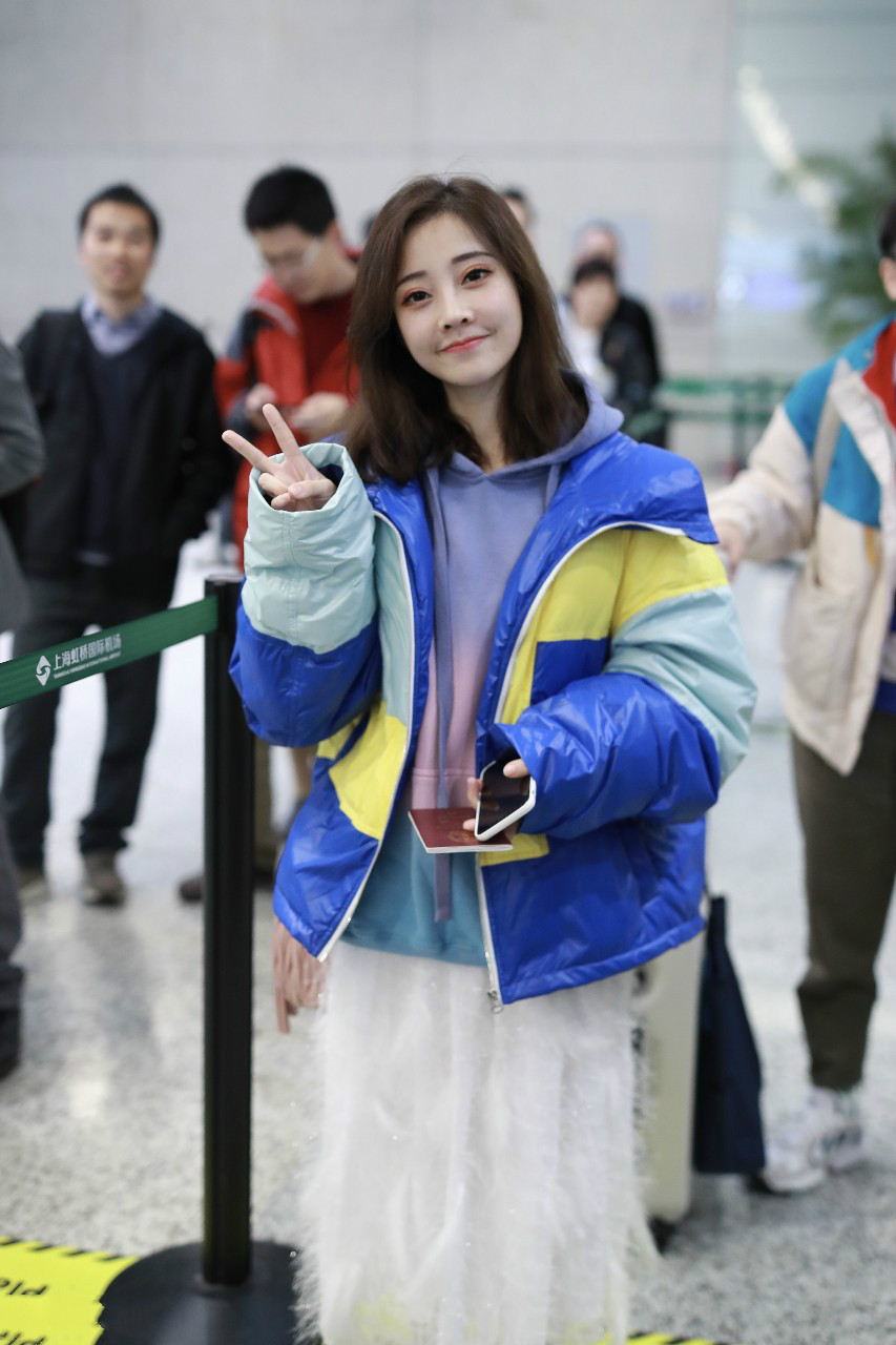 冯提莫穿拼色羽绒服搭配白色裙子现身机场,皮肤白皙笑容灿烂