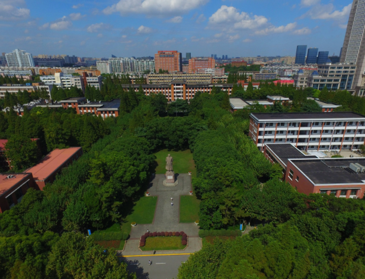 上海,航拍中国著名学府——复旦大学,绿树茂密郁郁葱葱,在蓝天白云的