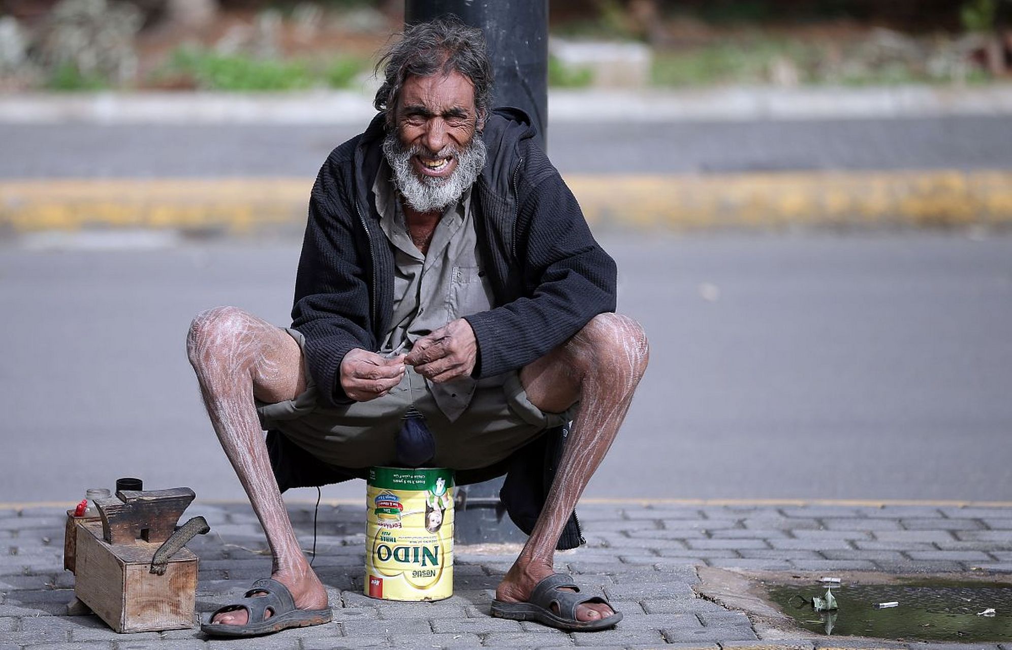 一个五六岁的小孩和坐在地上的流浪汉说:爷爷,新年好!
