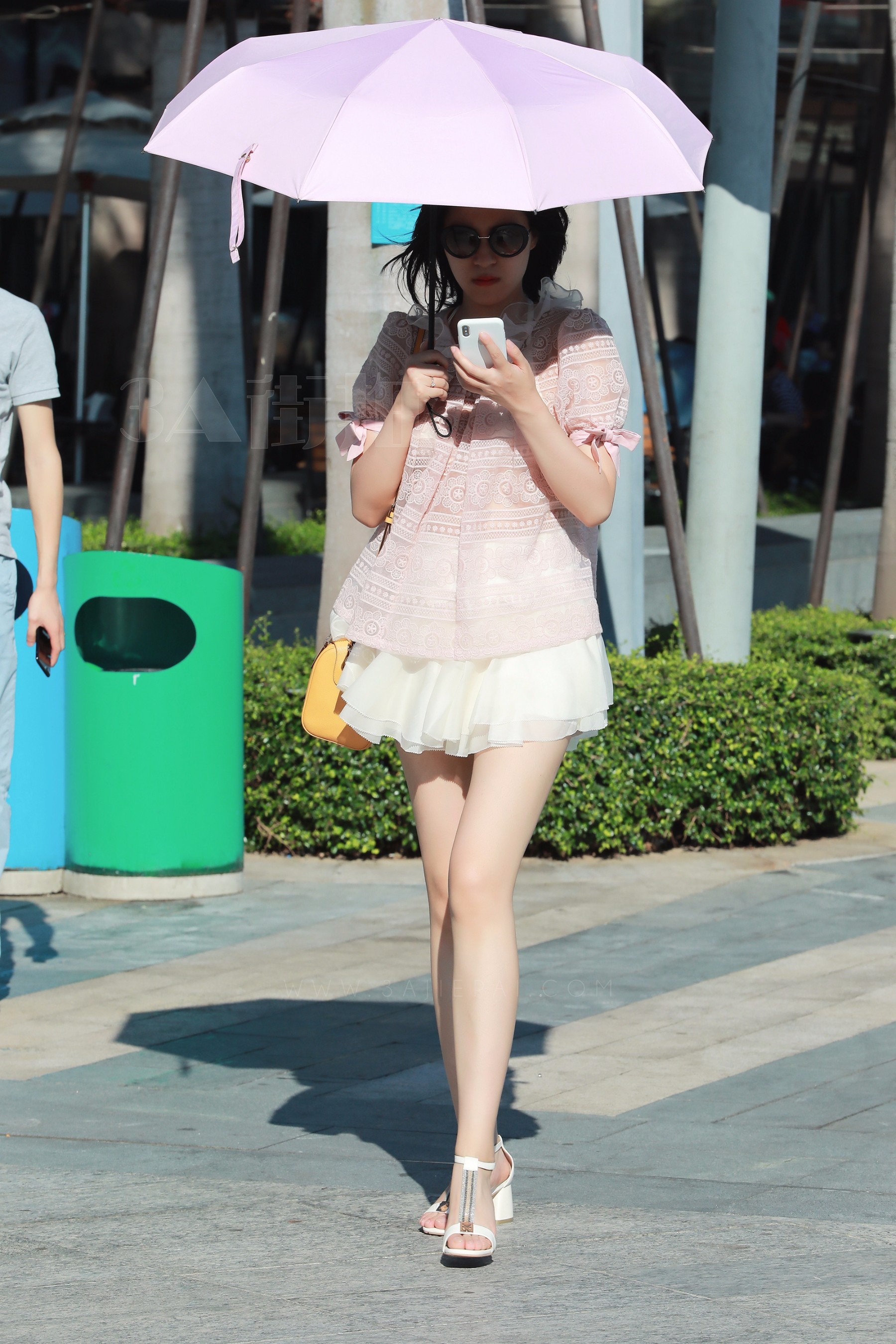 街拍:美女穿粉色镂空上衣配白纱短裙,秀出白皙美腿,很是抢眼