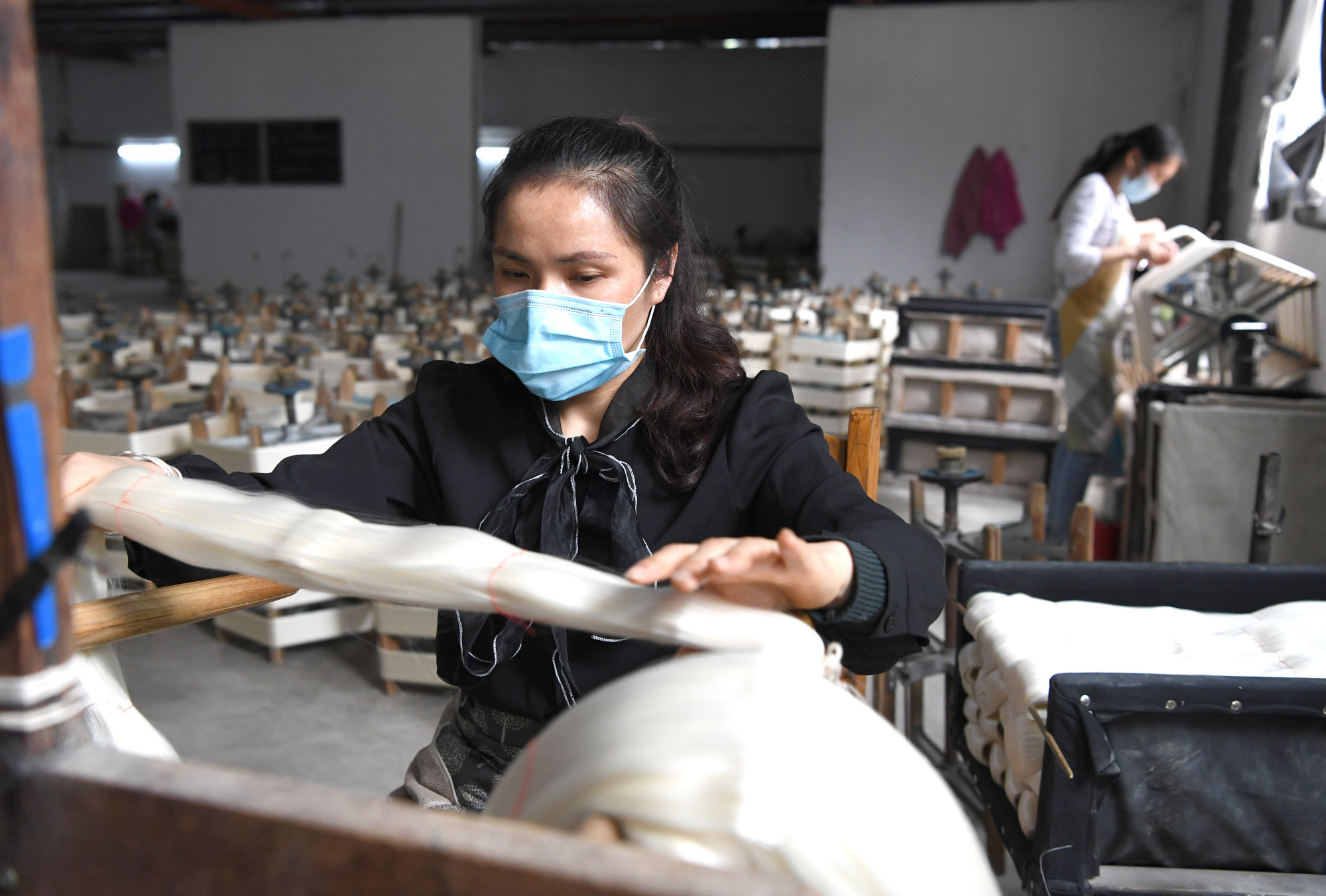 4月17日,工人在广西凌云县一家缫丝厂内整理蚕丝.