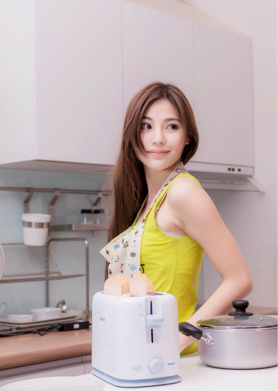 一个依偎在厨房都不忘留影的美女子