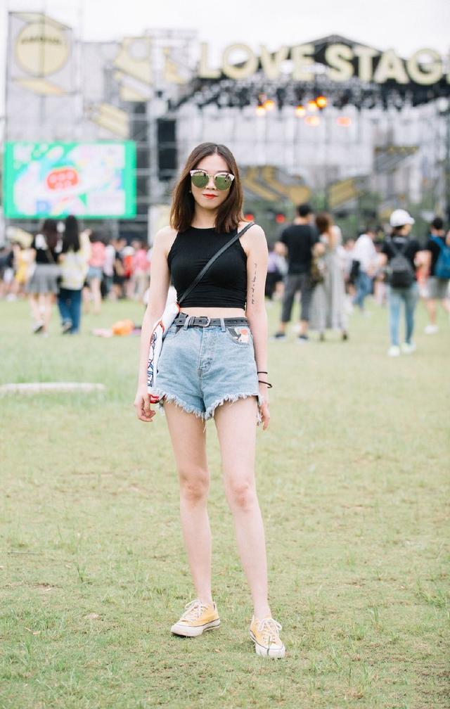 带着时尚太阳镜在公园游玩的妹子,牛仔短裤搭配黑色露脐装,尽显修长