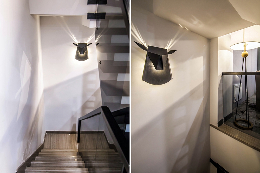 楼梯口的壁灯,在光影配合下,在墙面呈现鹿角的形状,充满设计感