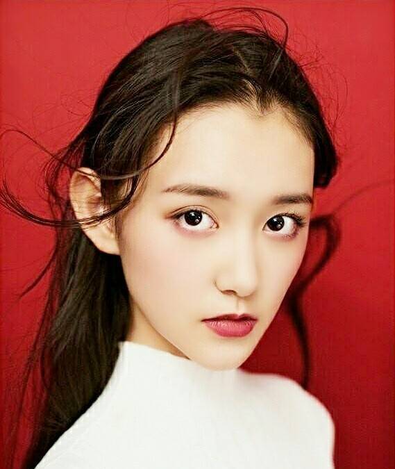 照片上的蒋依依,扎着两个丸子头,对着镜头做鬼脸好可爱啊.