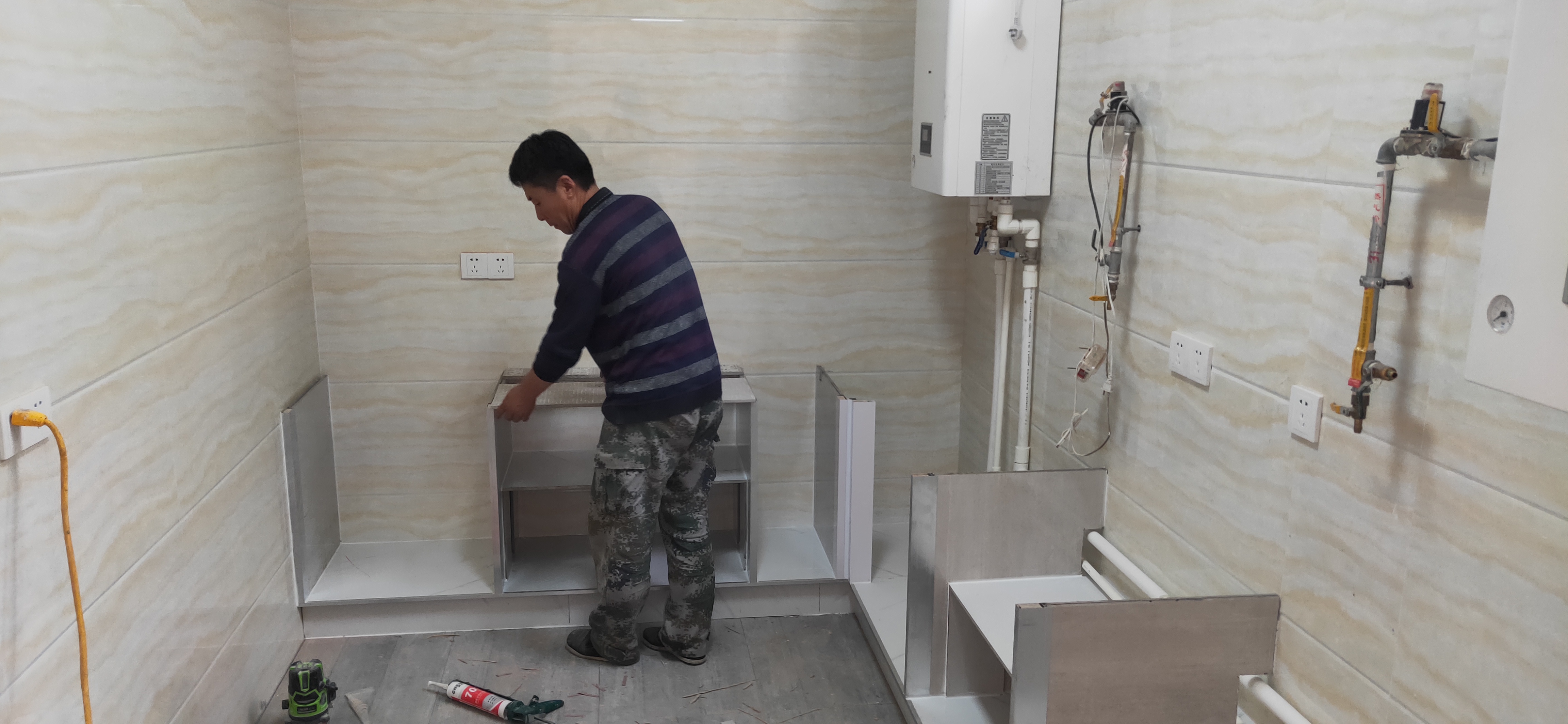 接着师傅再做灶台柜子,用比较大块的瓷砖,按照事先设计好的间距竖着