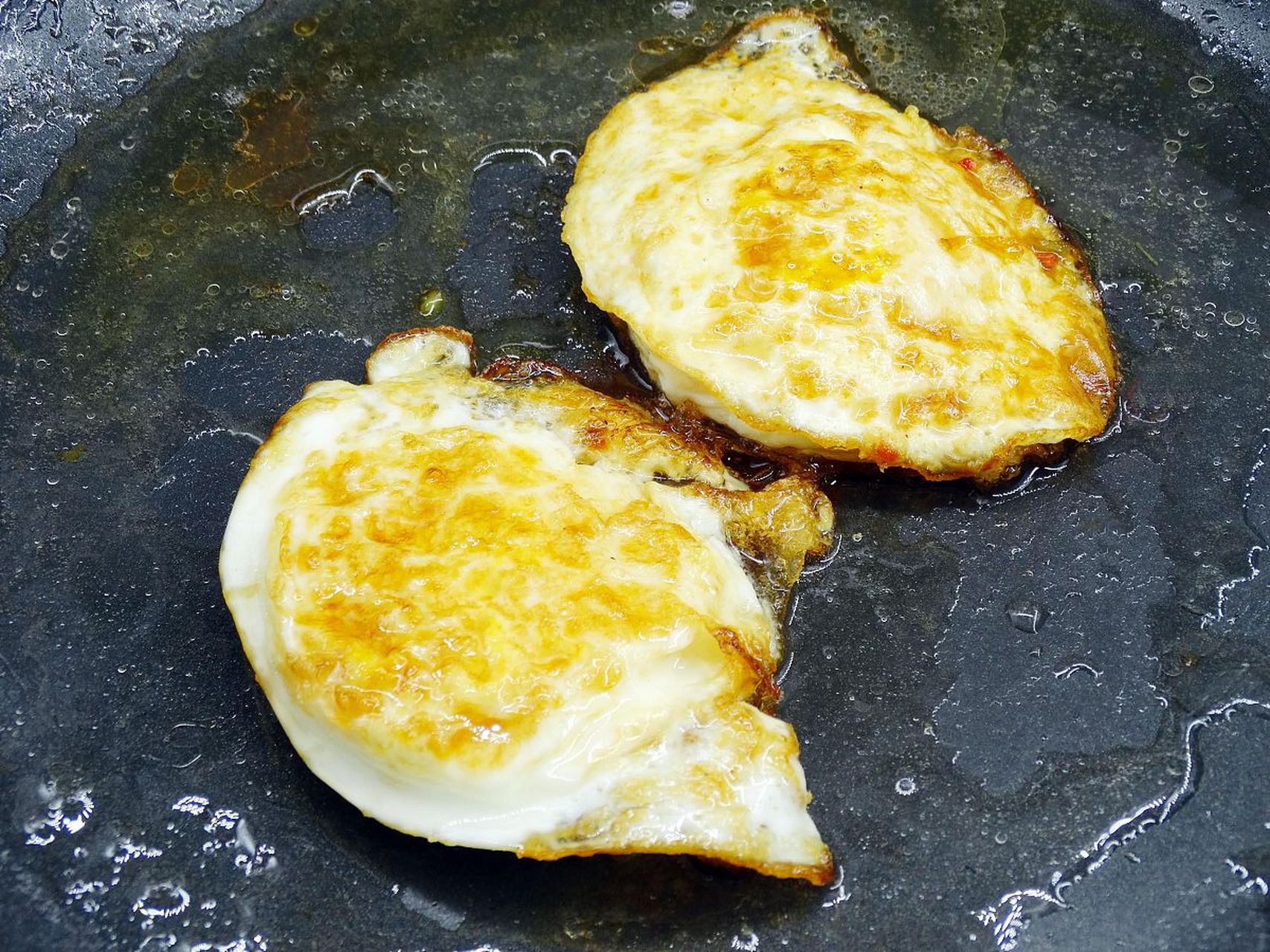 双面煎荷包蛋的做法一般是在平底锅中加入适量的油,将打好的鸡蛋