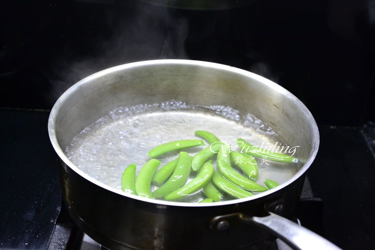 将甜豆2侧的老筋撕掉,然后烧开水加入几滴油,放入洗净的甜豆焯烫至