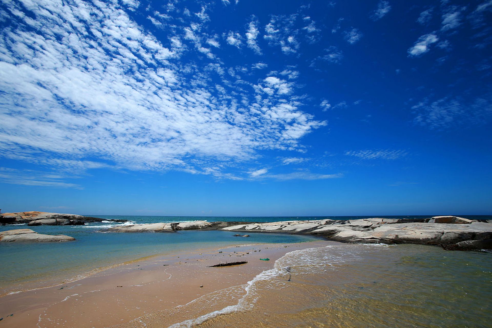 身处一片郁郁葱葱的椰林之中,海滩的浪花在脚边翻滚,夕阳的余晖映照