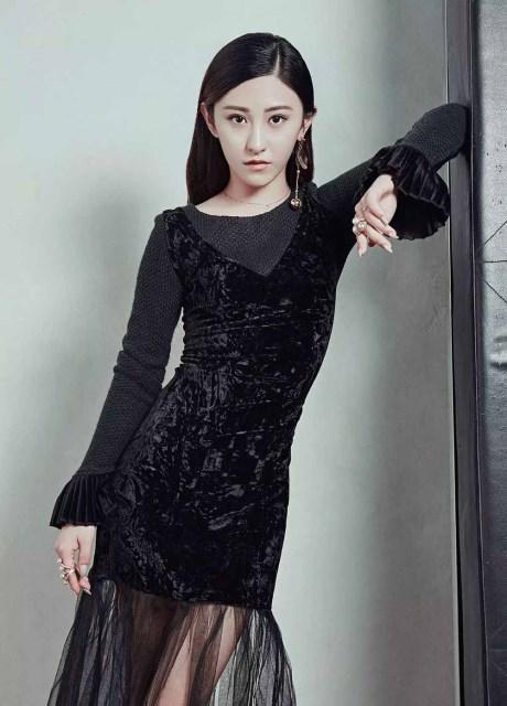 红色的背景与手中的玫瑰和指甲颜色相呼应,透着冷艳