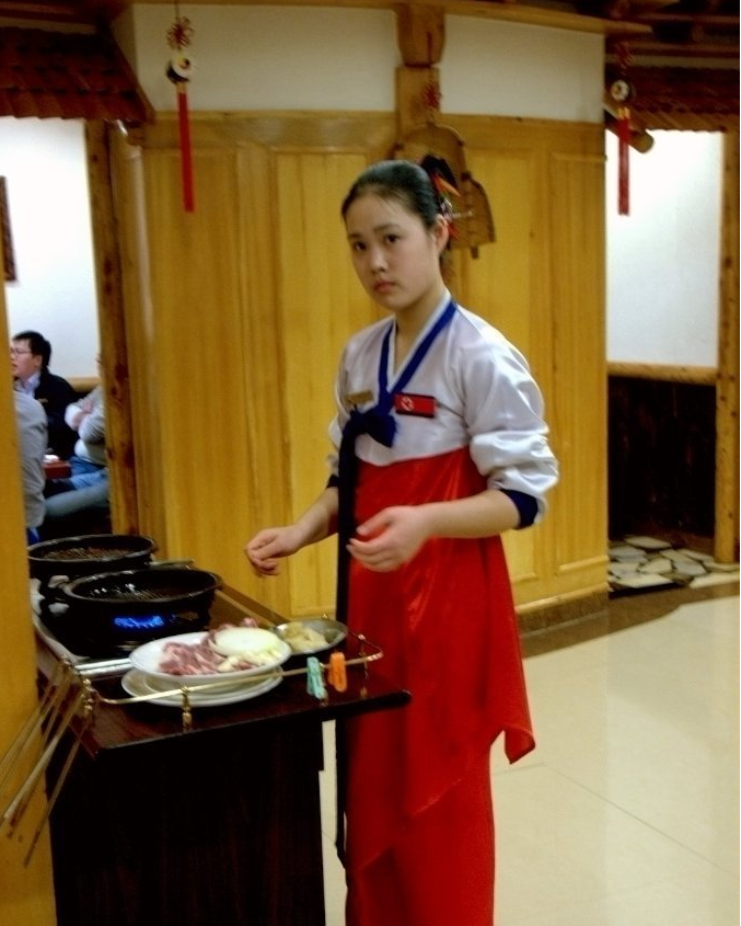 图为朝鲜一家餐厅的服务员,拿着话筒在唱歌.