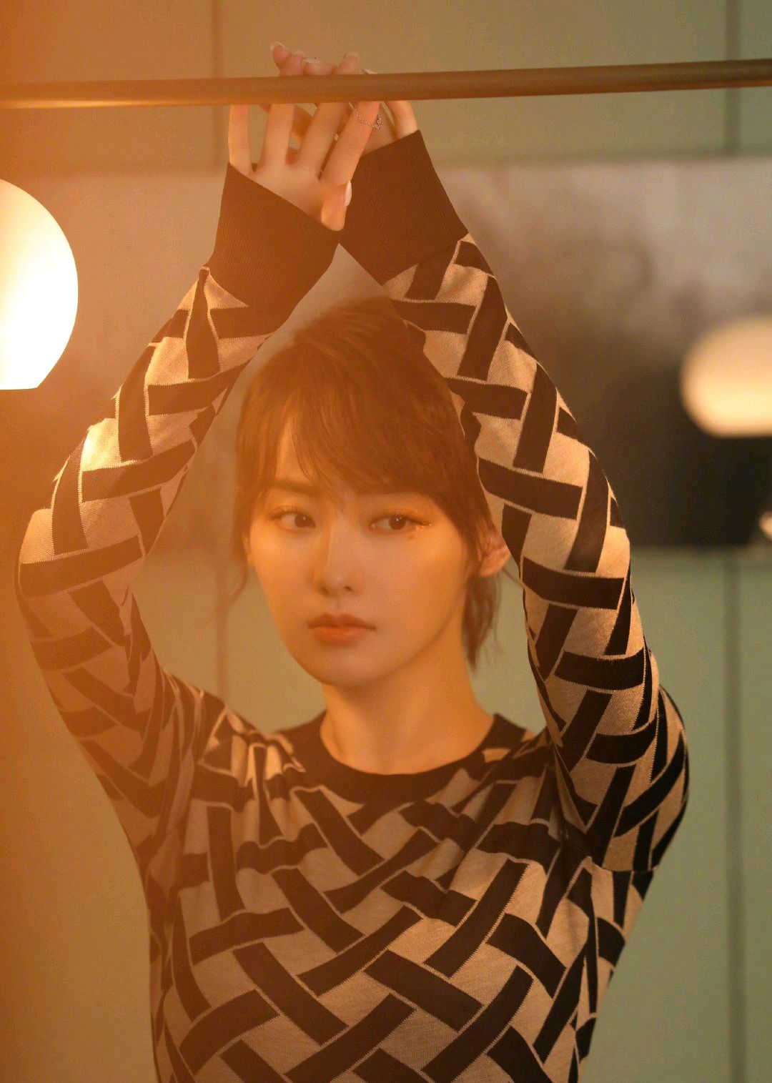 张嘉倪身穿焦糖色针织衫搭配羊绒半裙,橙色系落日眼妆与之呼应