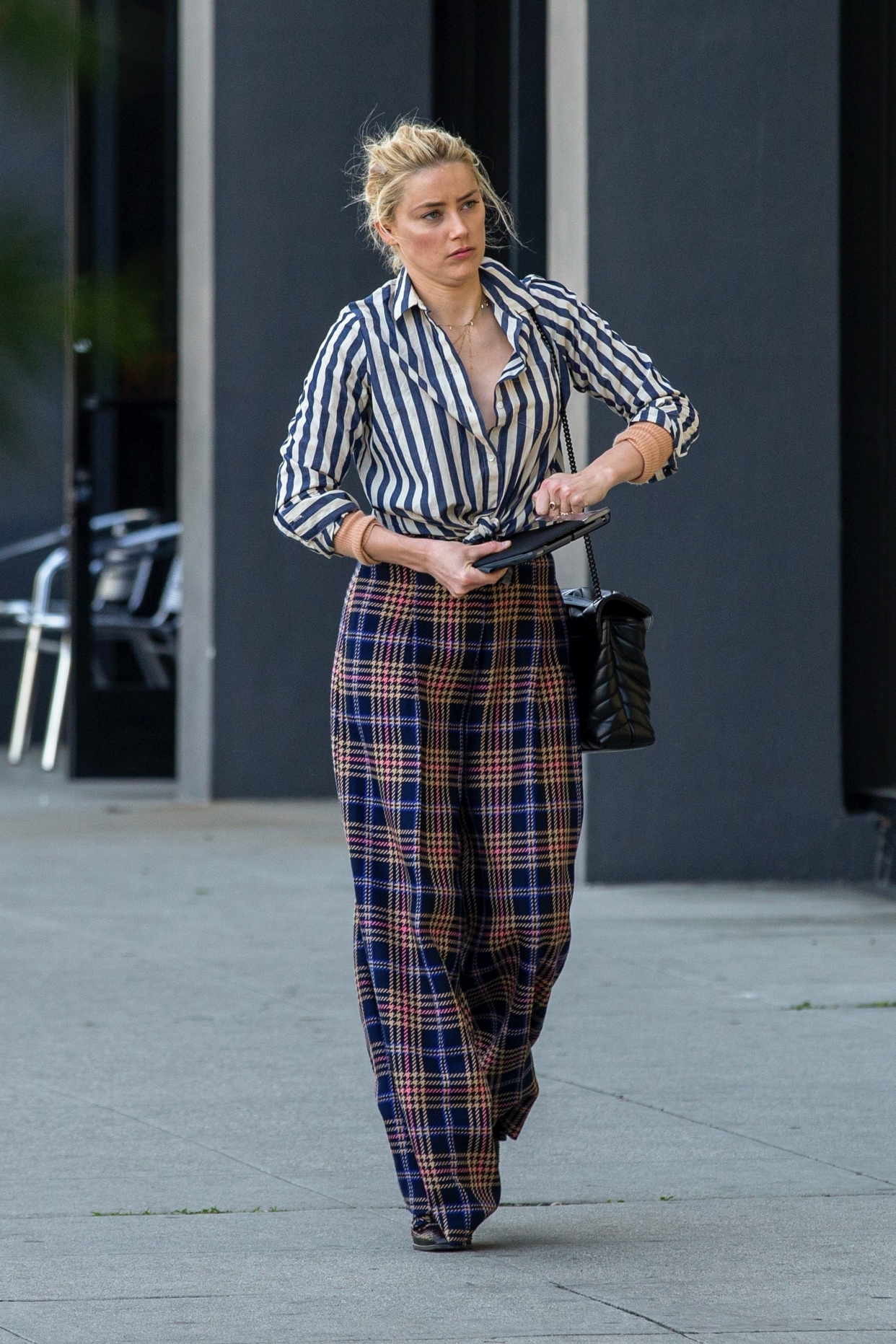 艾梅柏·希尔德穿条纹上衣搭配格子纹阔腿裤,略微有些憔悴