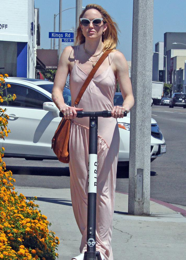 美国,凯蒂·洛茨(caity lotz)穿丝绸连衣裙骑滑板车外出,时尚动感