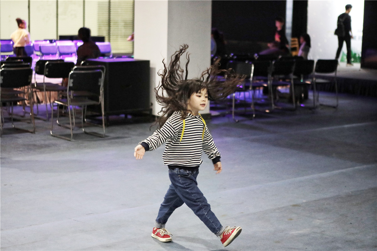 2018年10月28日,浙江湖州织里,一名童模在t台边练习模特步,她自信