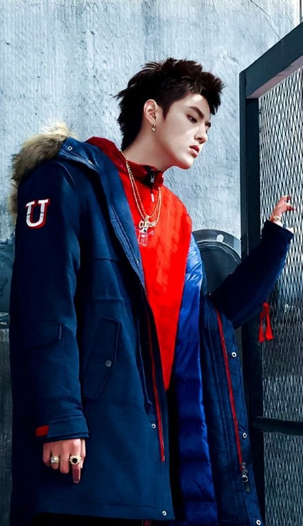 吴亦凡身穿一件灰色毛衣,脖子上围一个军绿色流苏围巾.