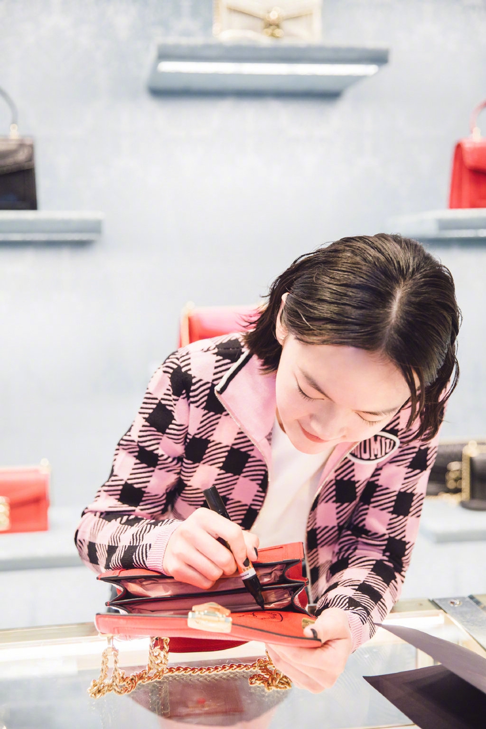 文淇出席品牌活动,粉色方格外套衬托文琪知性成熟气质,拿笔签名笑容