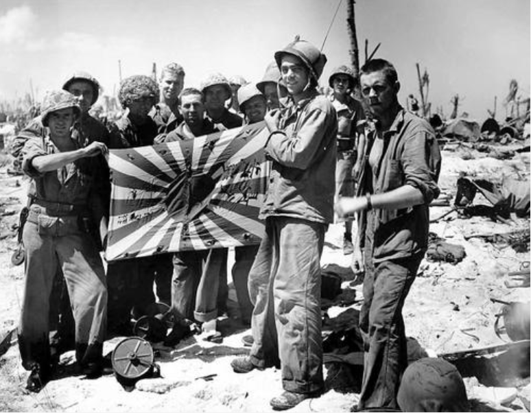 二战老照片,美军太平洋战场缴获大量日本旗帜,士兵兴高采烈合影