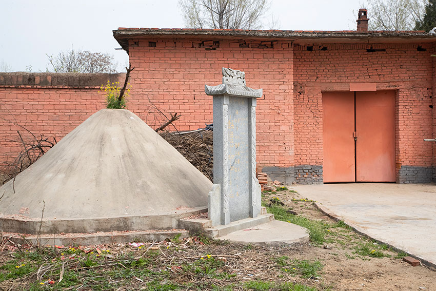 一位正在修坟的人说,有的地方是先有坟头,后盖房子,有的门前埋葬的是