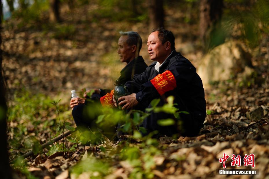 护林员王永仁(右)与同伴冉隆扩在巡山中小憩(来源:中国新闻网)