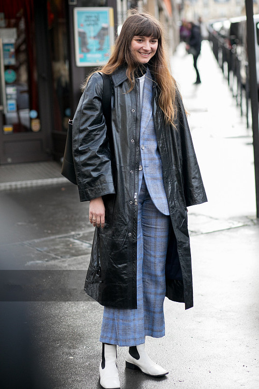 法国巴黎2018秋冬巴黎时装周潮人街拍,身穿黑色皮大衣,内搭蓝色格纹