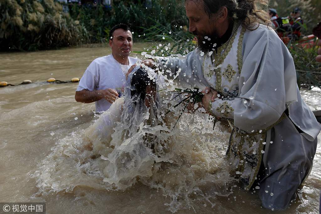 约旦河西岸:基督教朝圣者在泥水中受洗 庆祝主显节