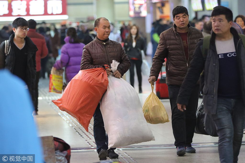 郑州火车站迎来春运高峰 旅客大包小裹赶火车