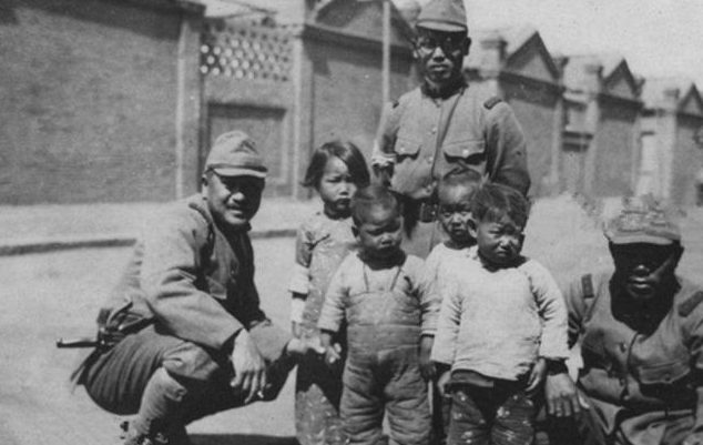 三个日本鬼子和四个稚气未退的中国小孩一起摆拍"中日亲善"的虚假宣传